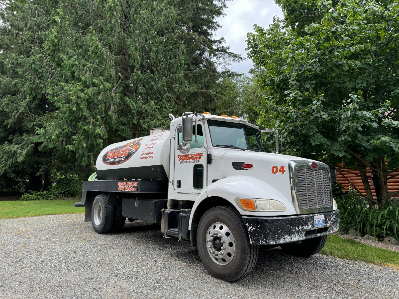 A Tiger Tank Pumping vacuum truck parked on a gravel drive.