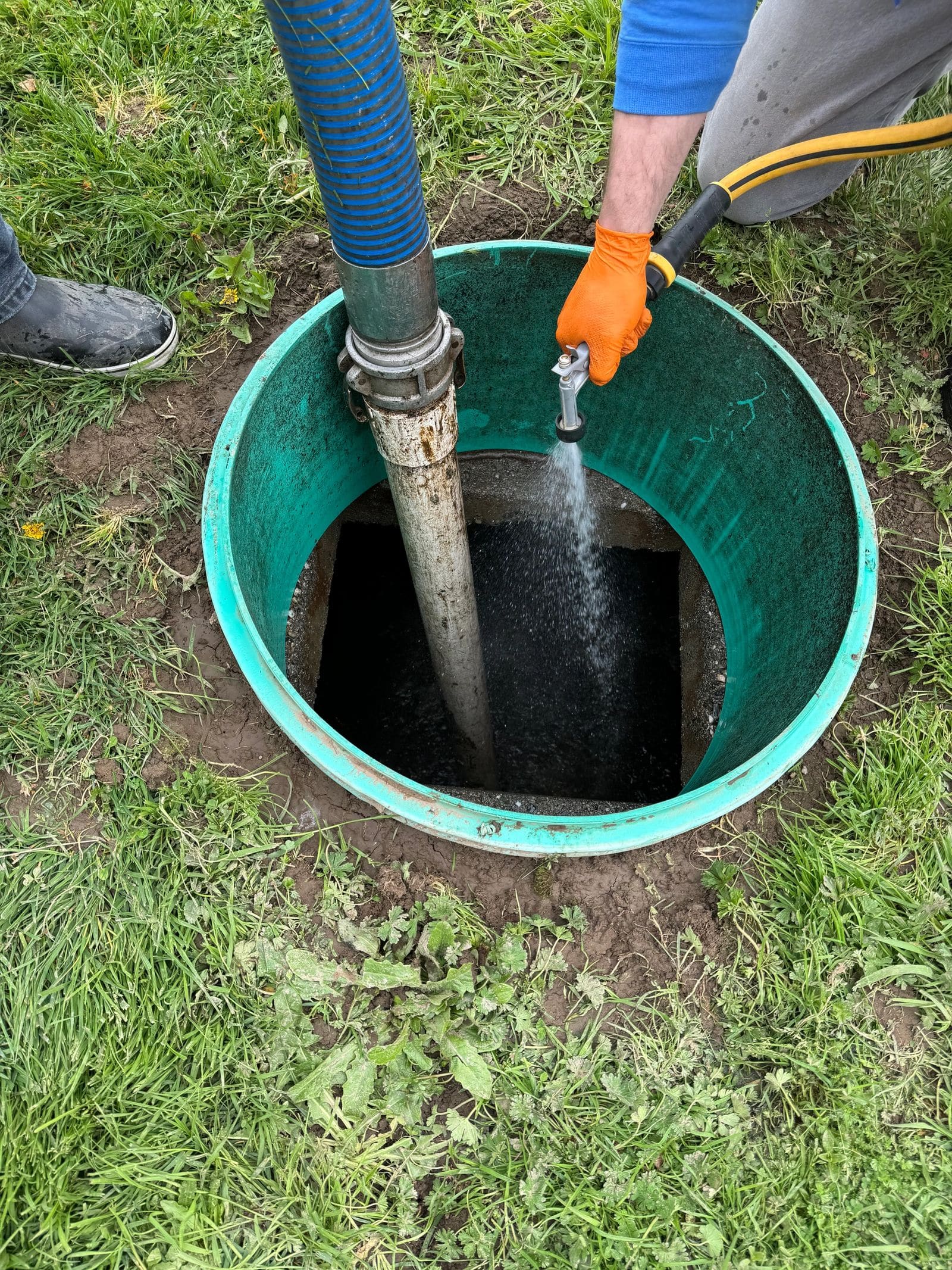 A septic tank being rinsed through its riser during a pump-out.